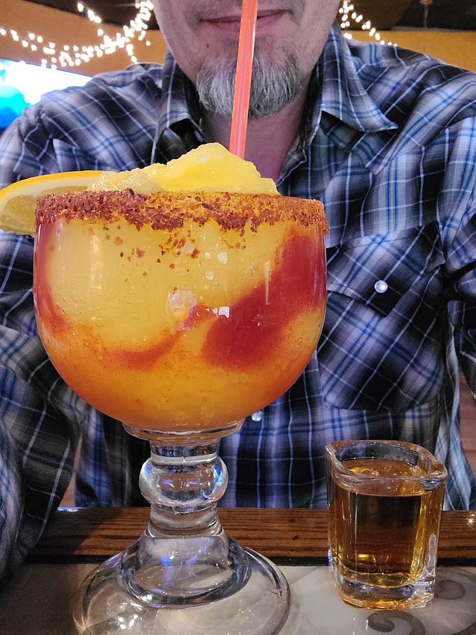 Restaurant menu laid out beside a drink glass.