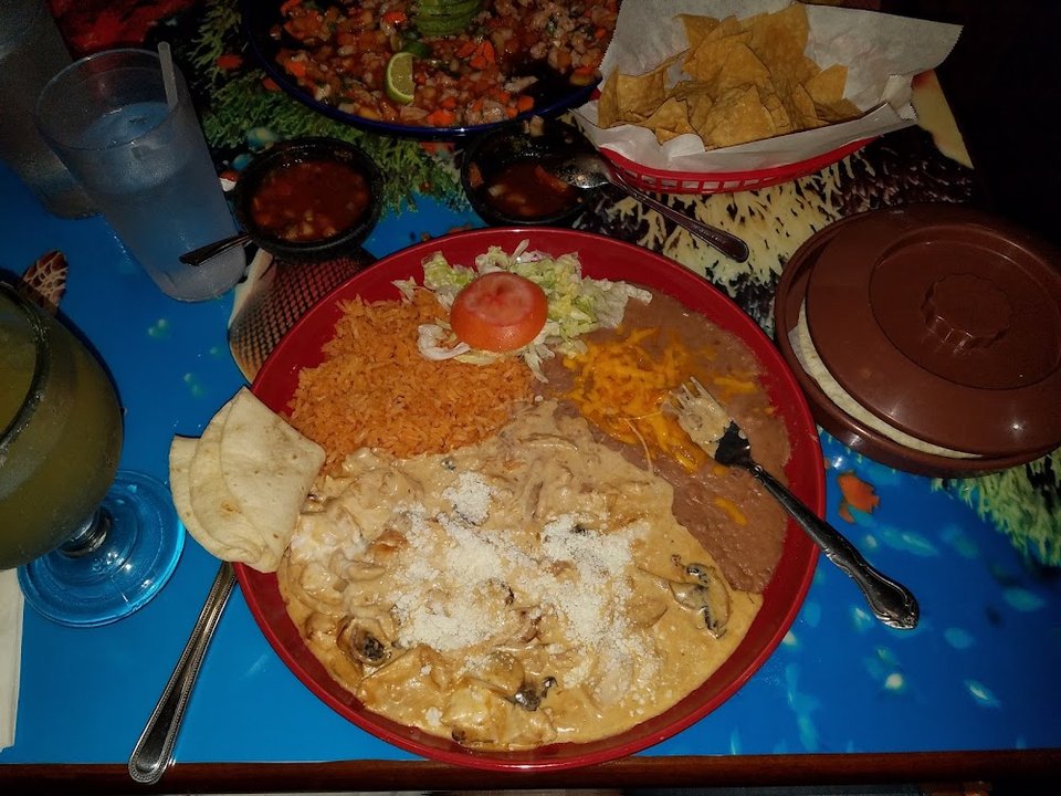 Restaurant menu laid out beside a drink glass.